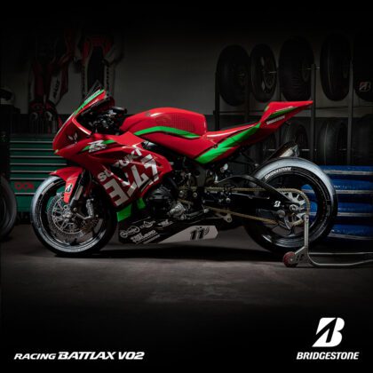 Rode Suzuki-motorfiets met Bridgestone banden in zijhoek