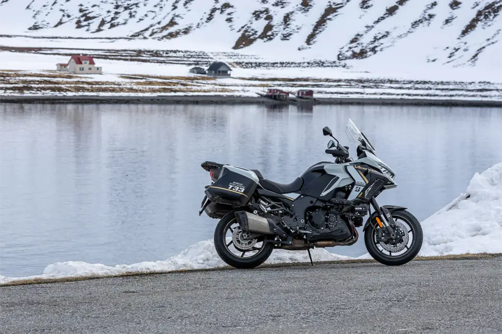Kawasaki Versys 1100 with Bridgestone T33 tyres parked by a serene lake on long-distance European journey.