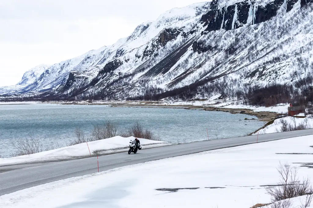 Rider on the E69 in snowy Norway, Bridgestone T33 tyres delivering grip and stability on challenging winter roads.