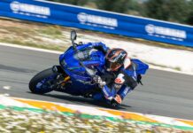Behind the scenes at the Yamaha R7 press launch on Bridgestone tyres Motorcyclist cornering at speed on a blue Yamaha sportbike on a racetrack.