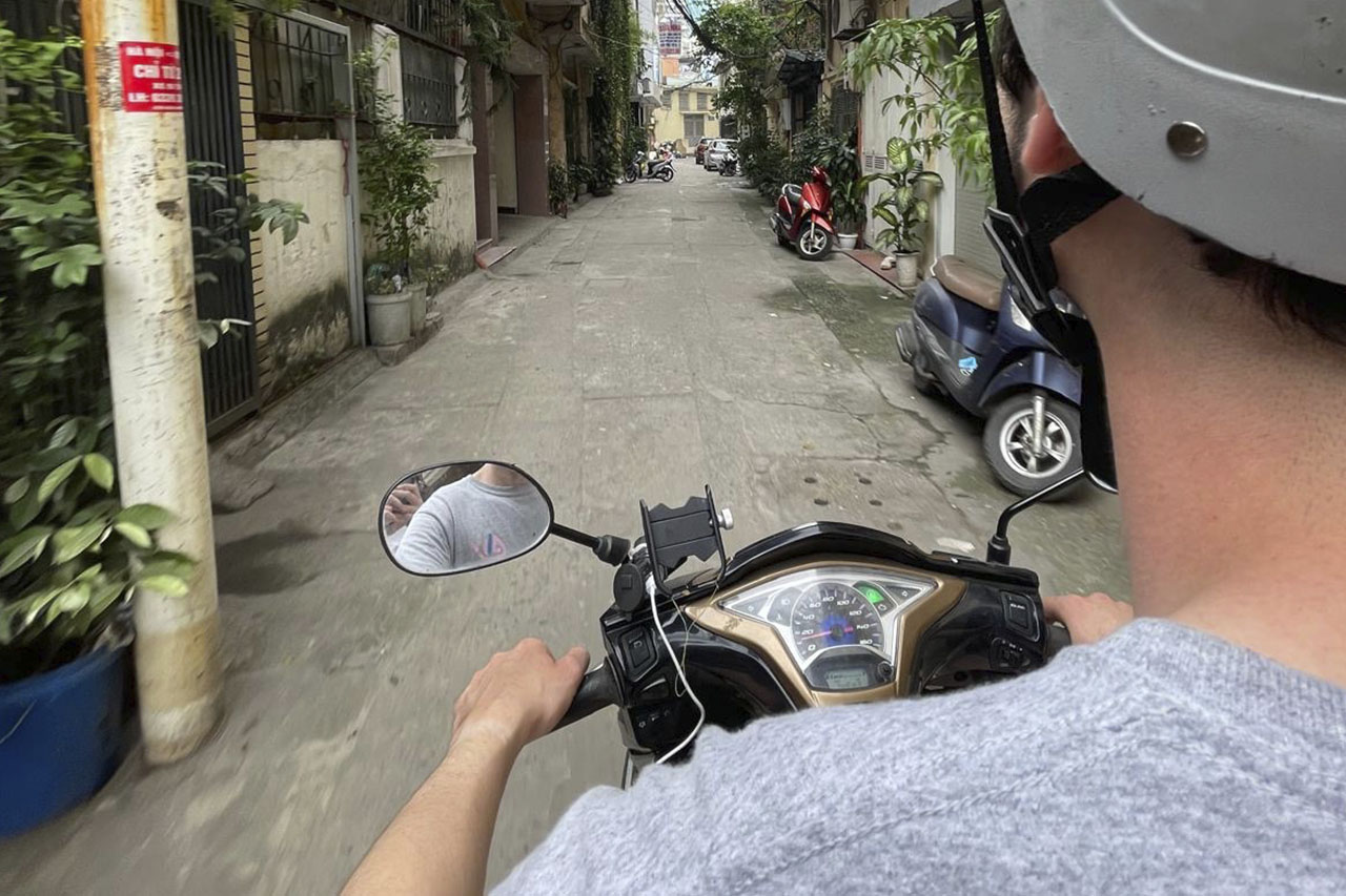 First-person view riding a scooter down a narrow alley