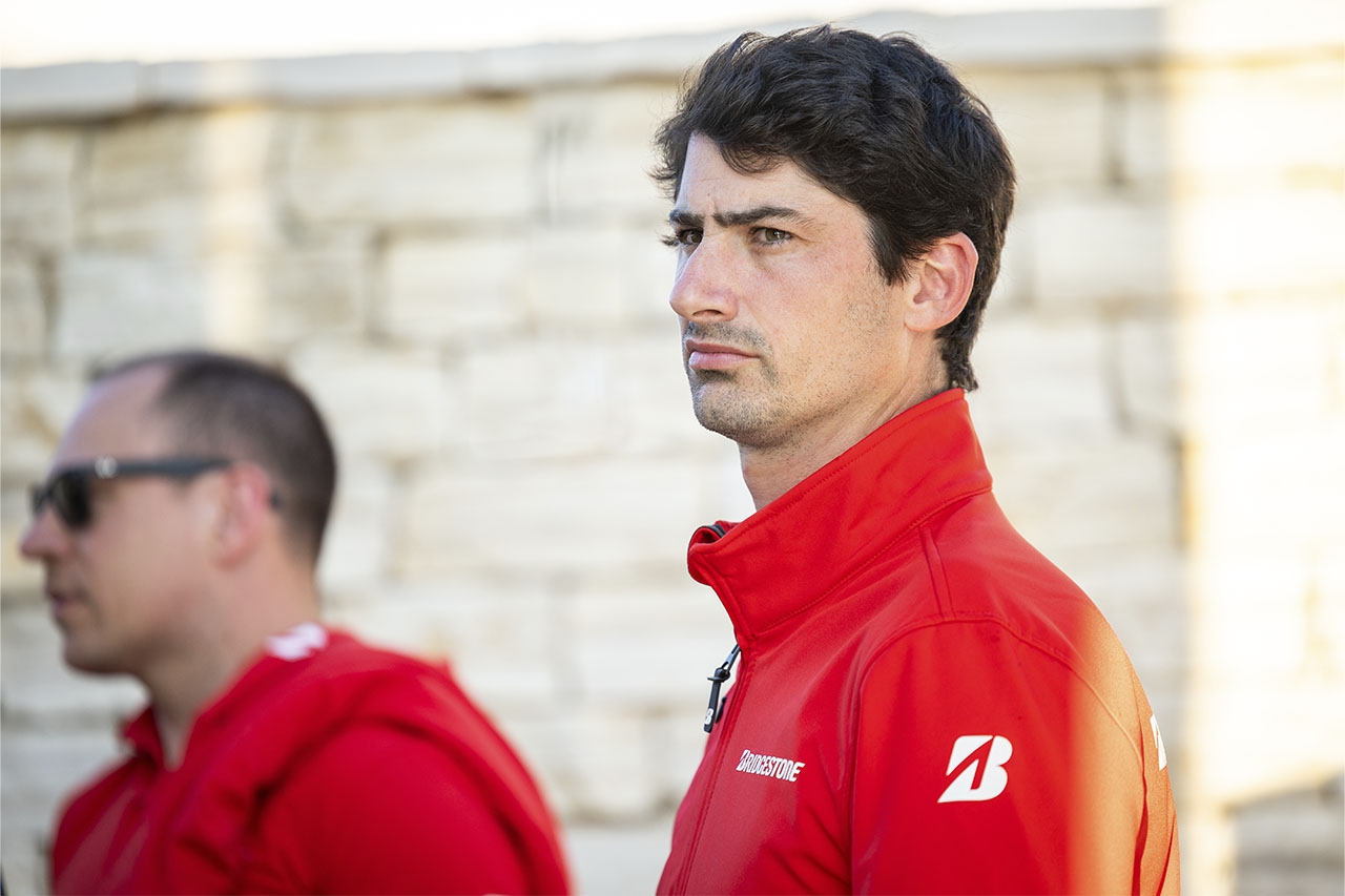 Hubert in his red Bridgestone jacket, with a teammate in the foreground