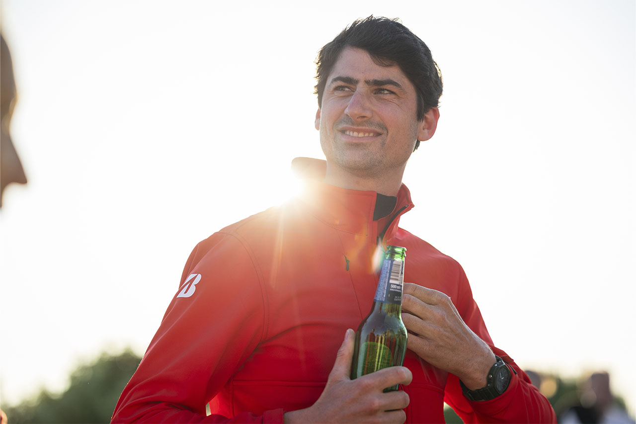 Hubert smiling in the sunshine with a drink in hand